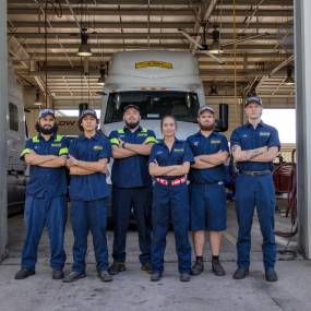 mechanics pose in front of truck