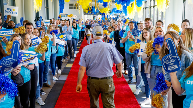 J.B. Hunt driver walking the million mile red carpet with cheering j.b. employees on either side