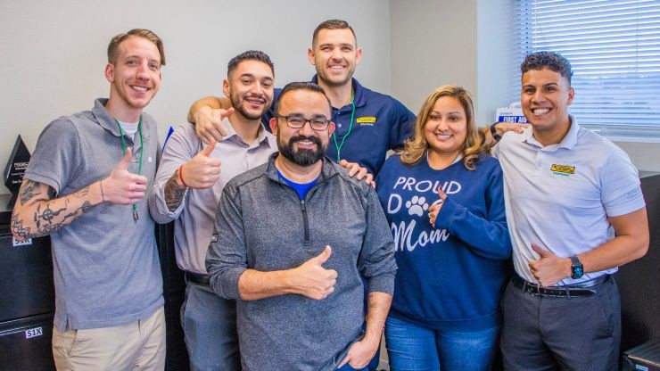  J.B. Hunt employees giving a thumbs up inside of an office building