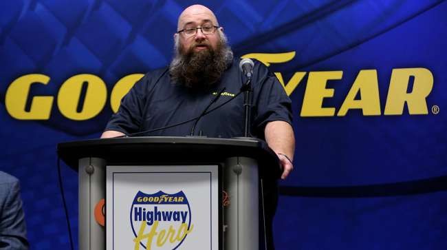 Goodyear Highway Hero, Andrew, gives speech behind podium. 
