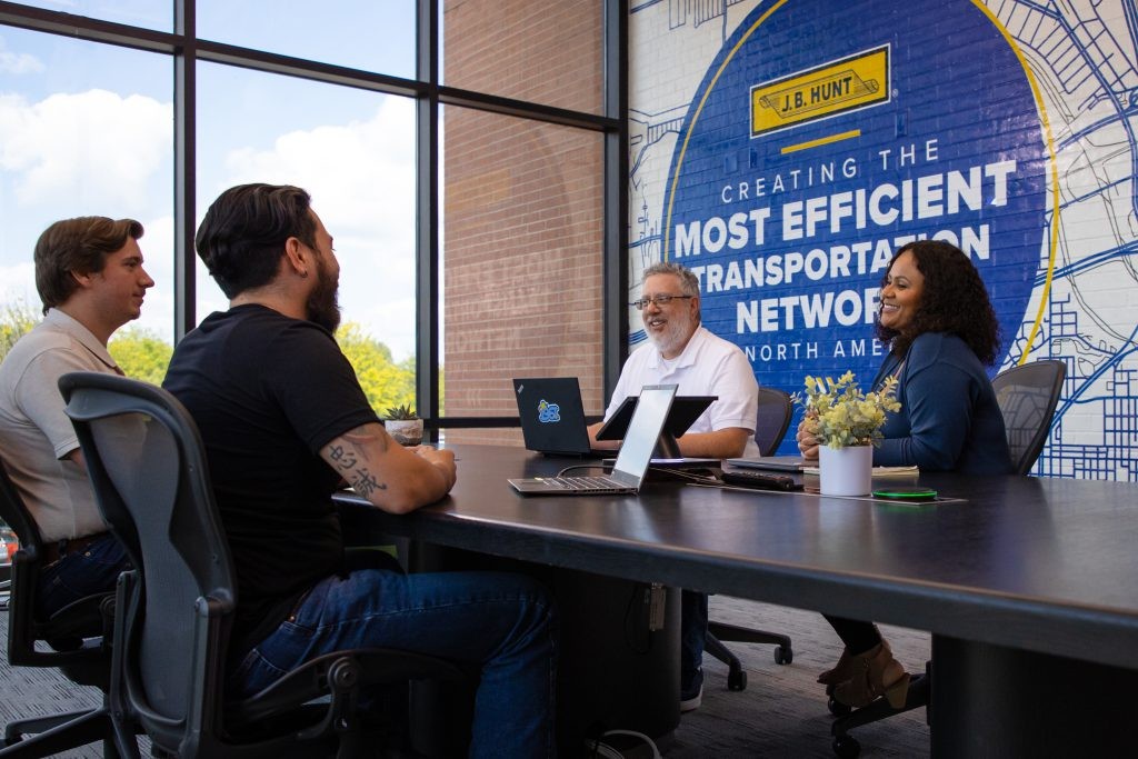 A group of J.B. Hunt employees meeting in a conference room at the J.B. Hunt corporate headquarters.