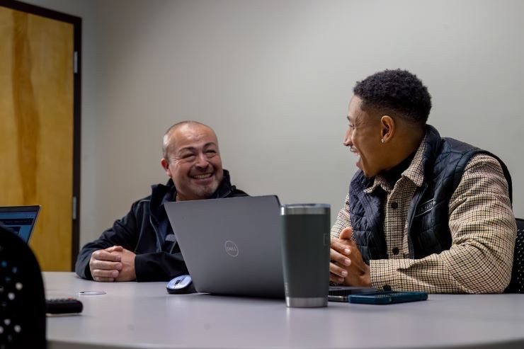 Two J.B. Hunt employees looking at each other and smiling in a meeting.