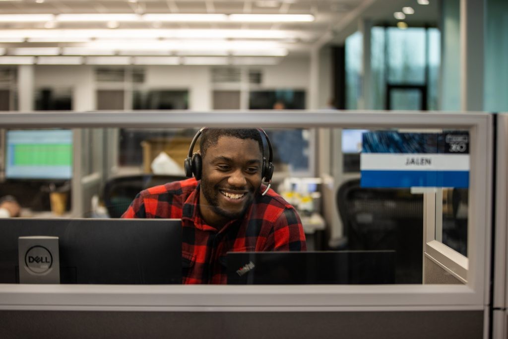 An office employee working at their desk with a headset on.