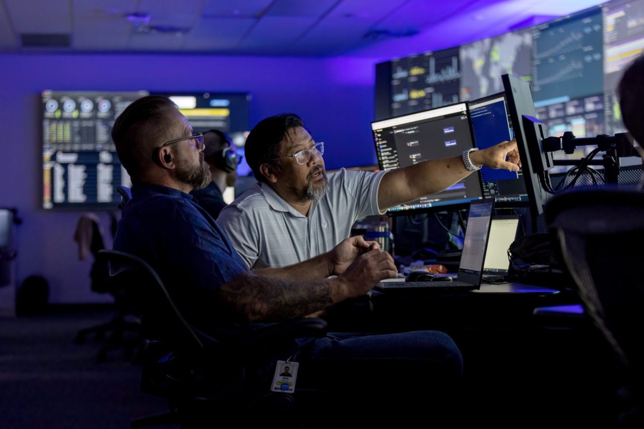 Two employees collaborating on work while looking at a computer screen.