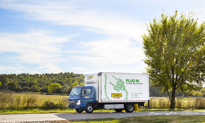 J.B. Hunt all-electric, medium-duty box truck parked on a country road.