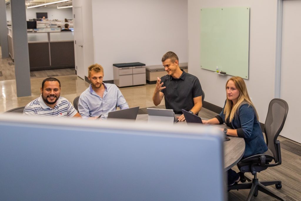 J.B. Hunt employees gathered around a table in a conference room.