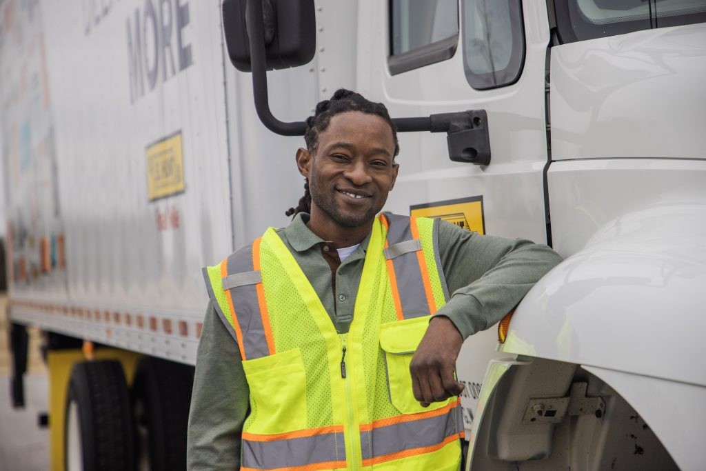 Julian standing next to a box truck and smiling.
