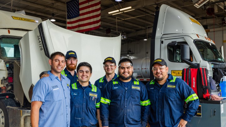 group of diesel mechanics pose in shop
