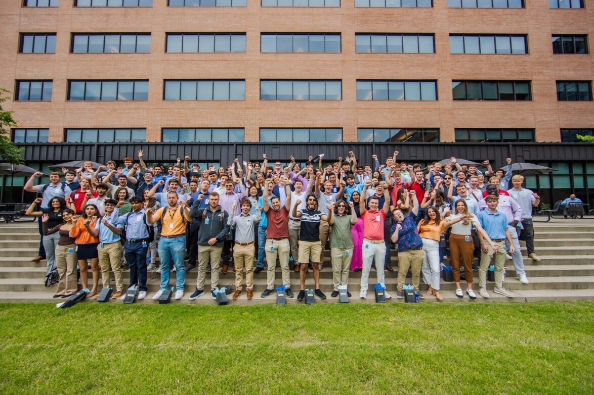 A group of interns posing for a photo on the steps of the J.B. Hunt corporate campus.