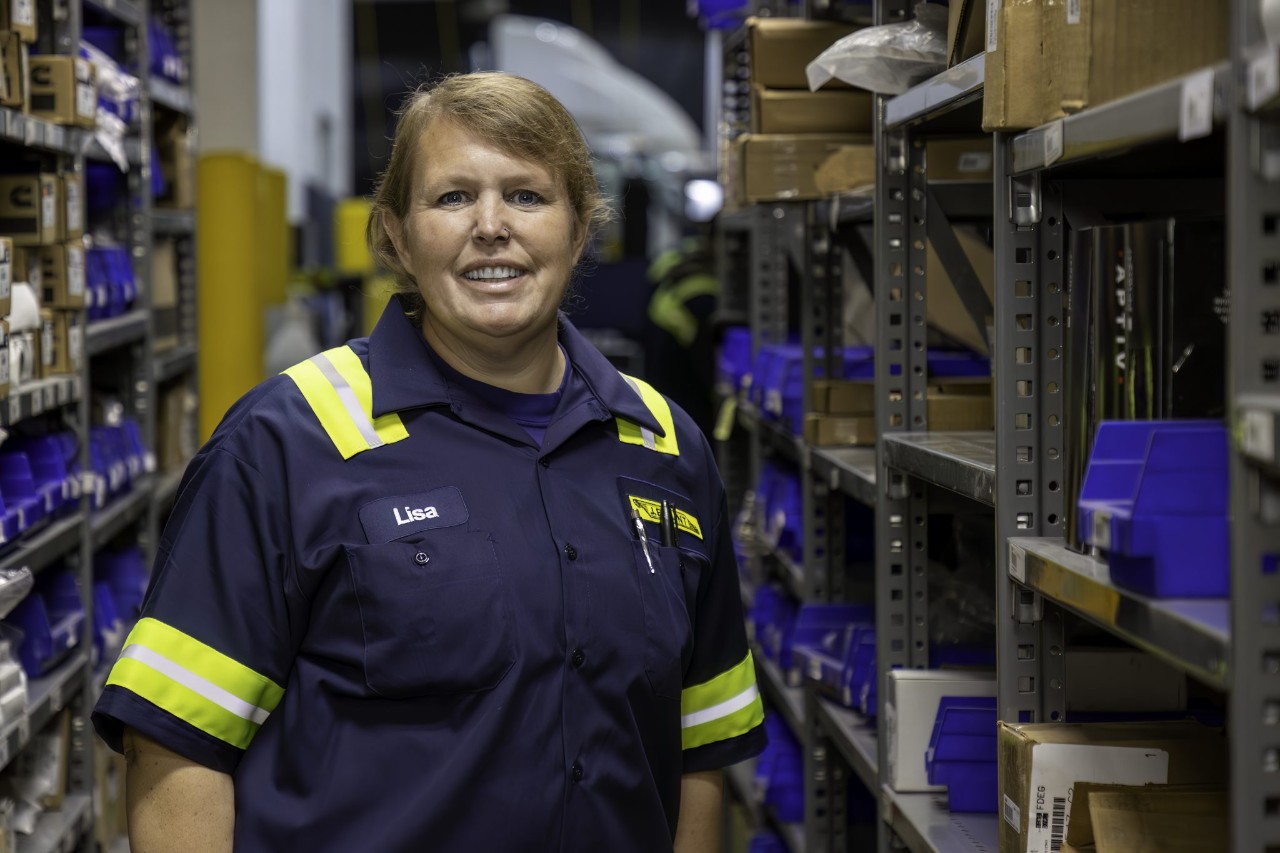 Woman standing in a storage warehouse aisle.