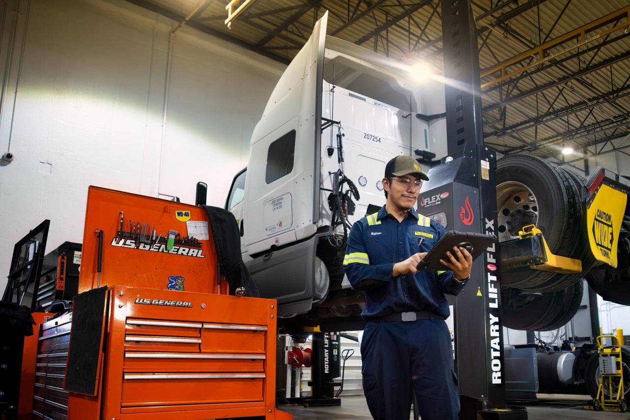 A J.B. Hunt maintenance tech looking at a tablet