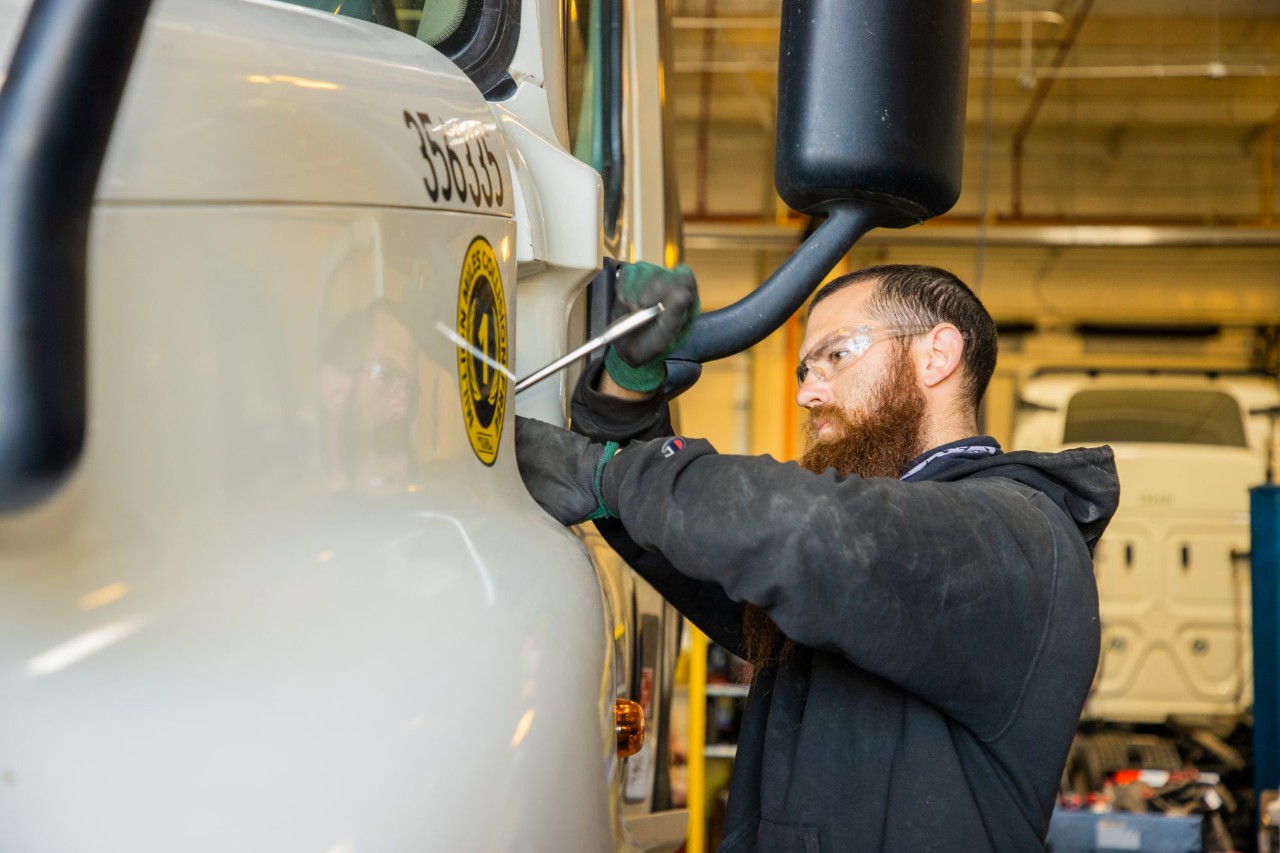 Maintenance technician working on a J.B. Hunt truck.