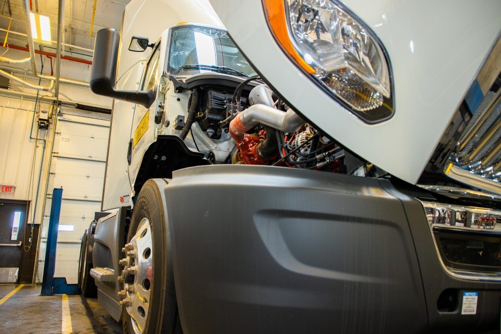 J.B. Hunt truck with exposed engine in maintenance garage