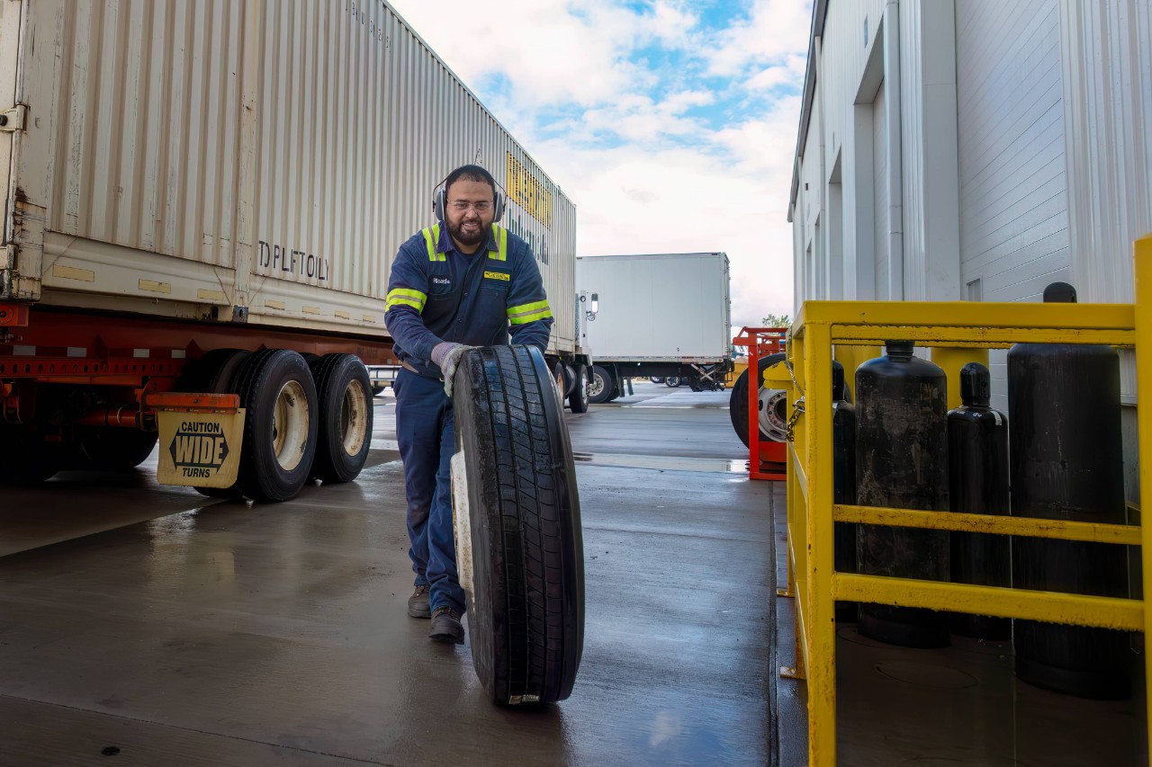 J.B. Hunt technician smiling while working on equipment in our Joliet, Illinois shop.