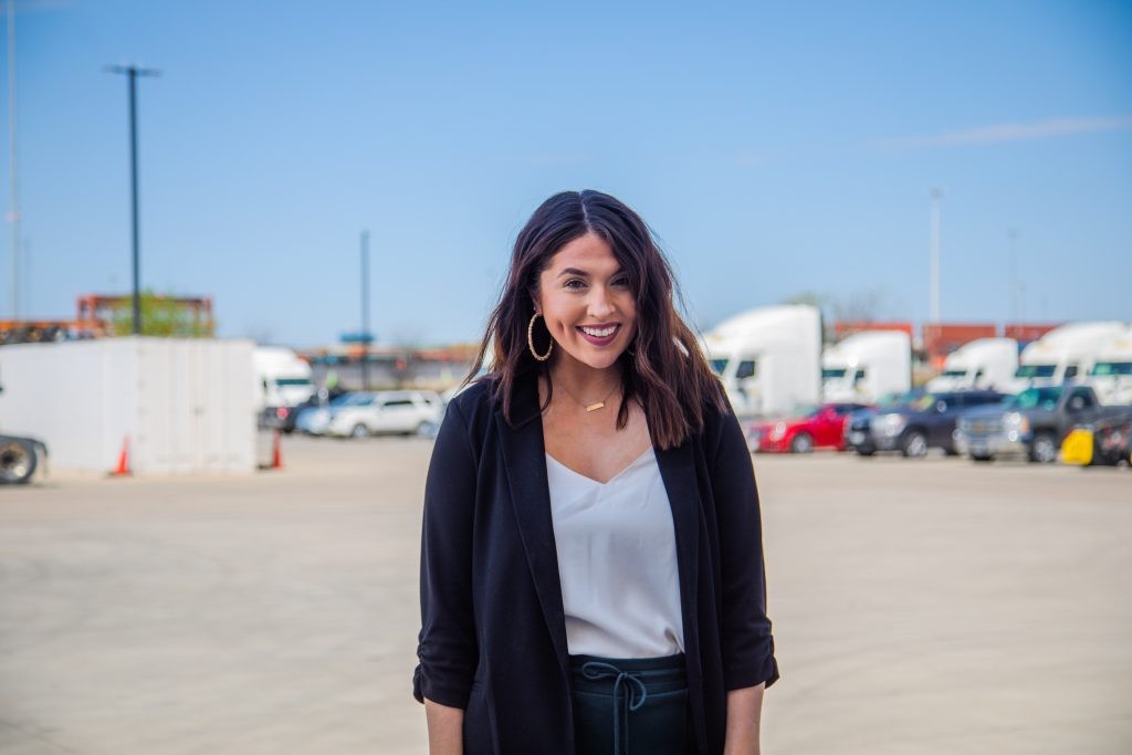 A J.B. Hunt operations employee posing in front of trucks.