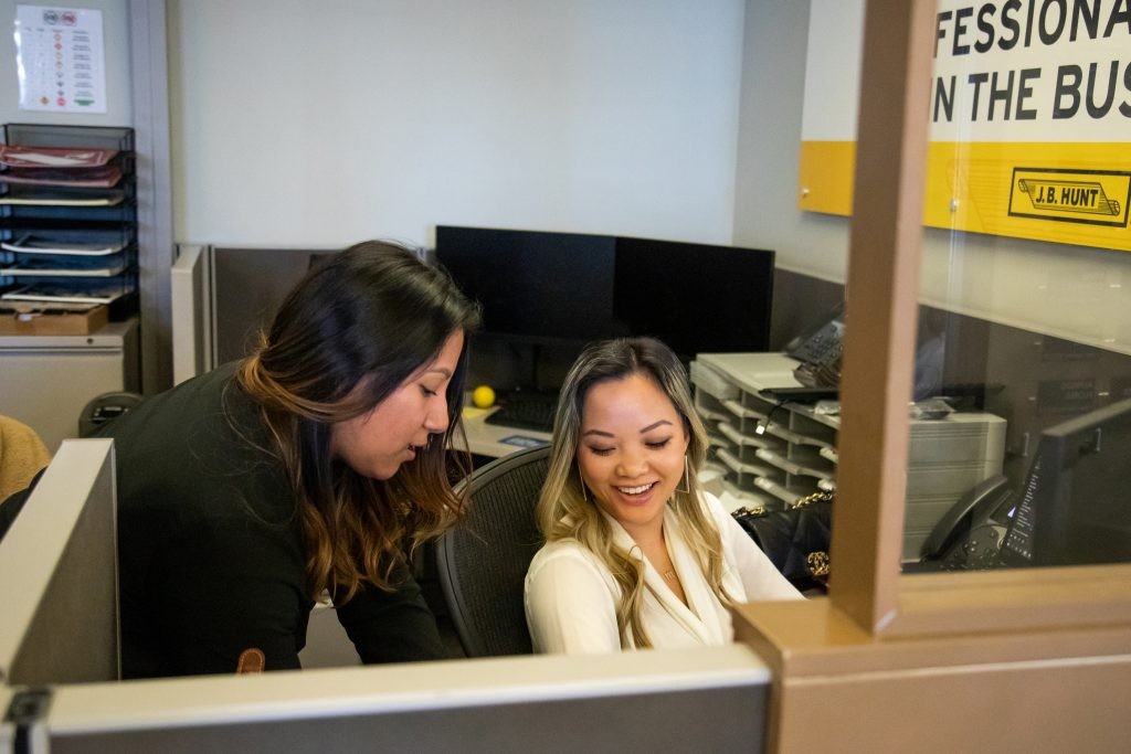 Two J.B. Hunt operations employees working at a desk.