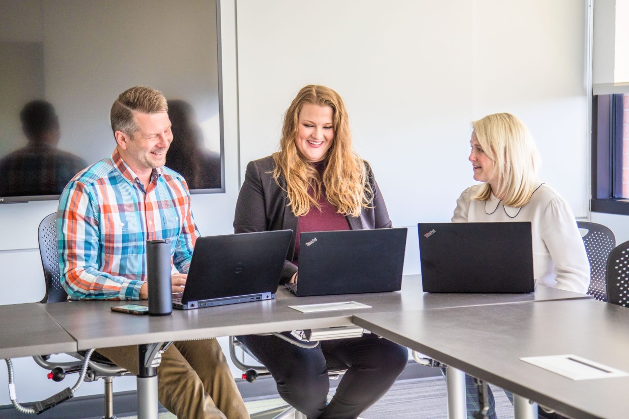 J.B. Hunt sales employees working together in a meeting room.