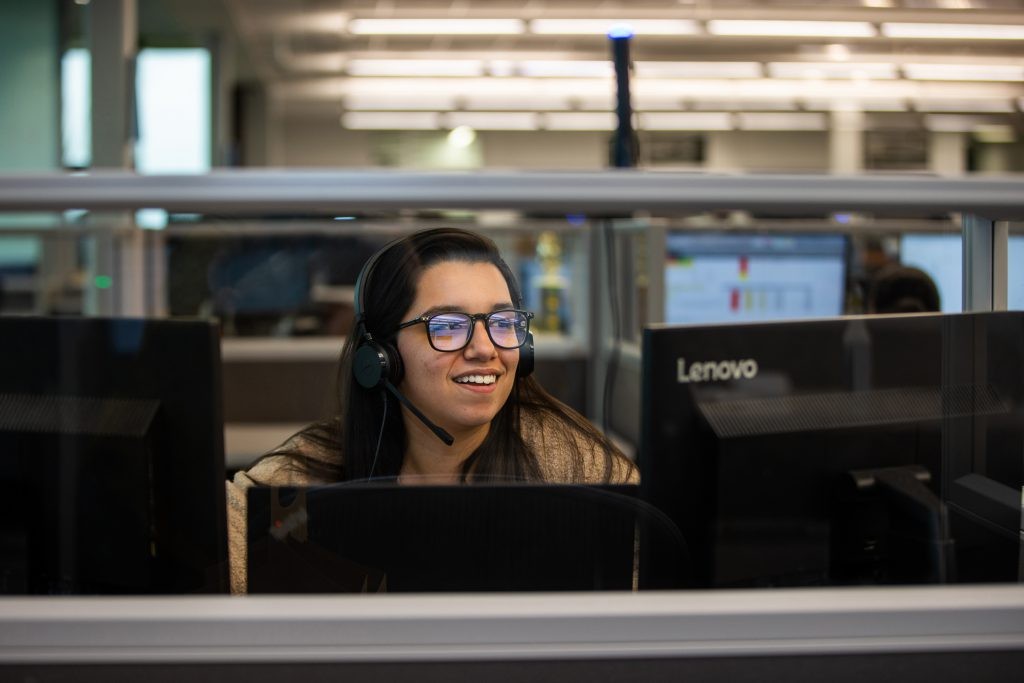 J.B. Hunt employee working between two computer monitors at desk