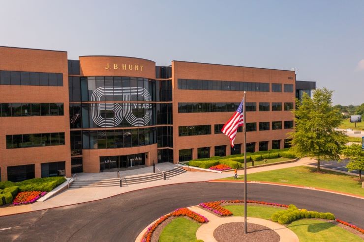 A drone photo of the front of the J.B. Hunt corporate office with a 60 years decal over the windows.