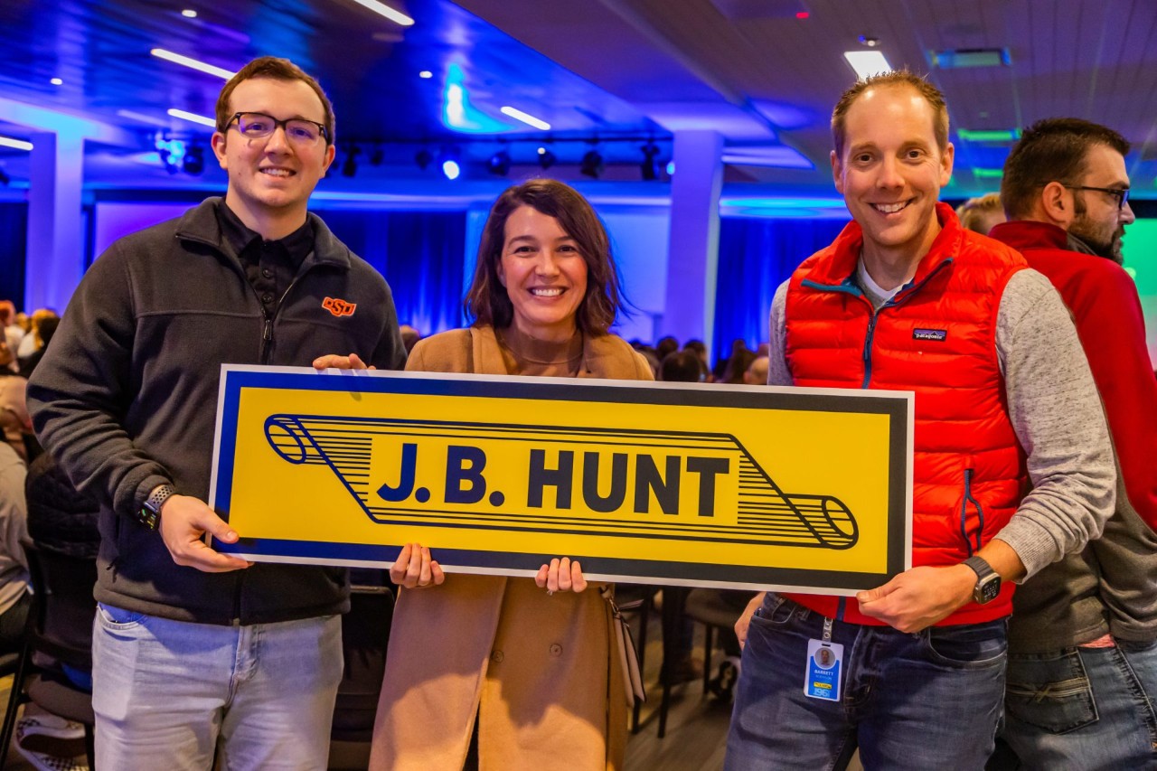 Employees holding up the J.B. Hunt scroll cutout.