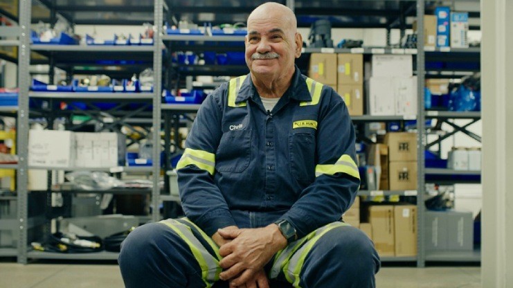 Mobile Technician, Chris, sitting in a J.B. Hunt maintenance shop sharing about how his work environment contributes to his happiness. 