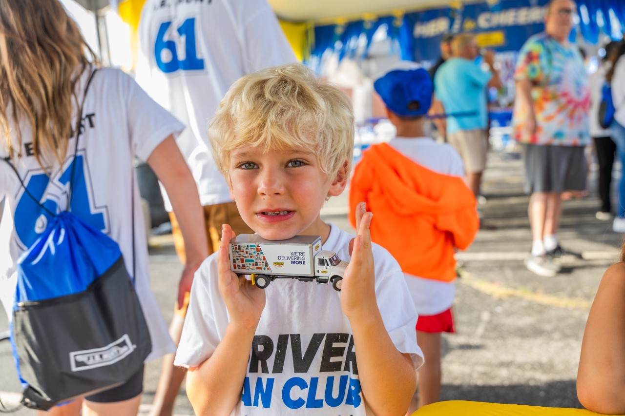 Little boy holding J.B. Hunt toy truck.