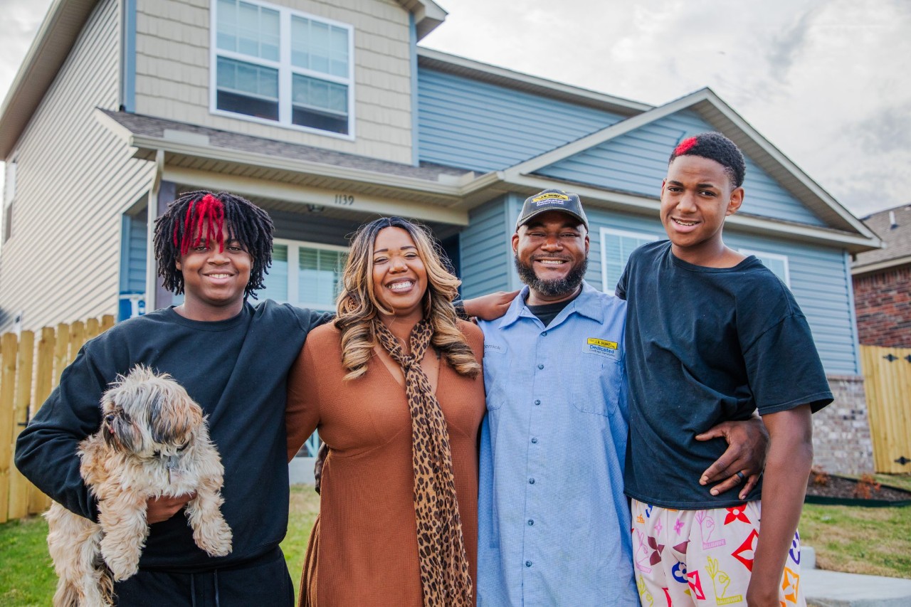 J.B. Hunt driver, Derrick, and his family posing at their home.