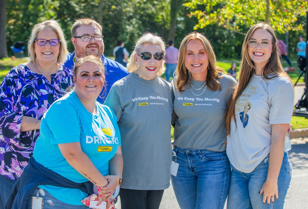Johnelle Hunt and Shelley Simpson pose with J.B. Hunt employees at company event.