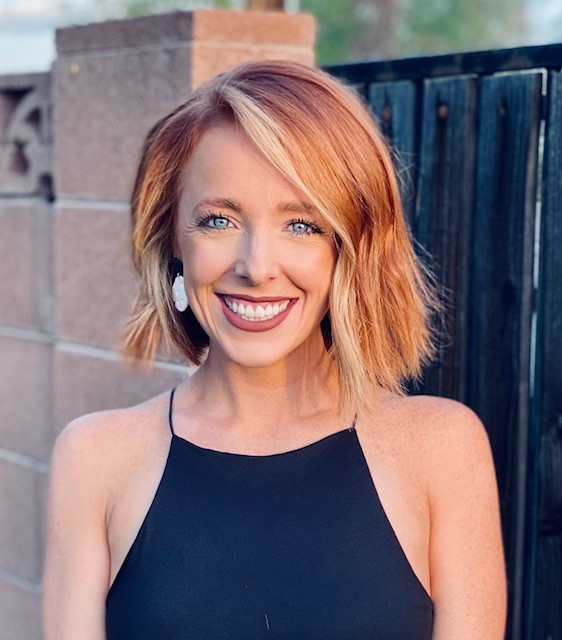 Client Manager, Hannah smiling in front of a fence