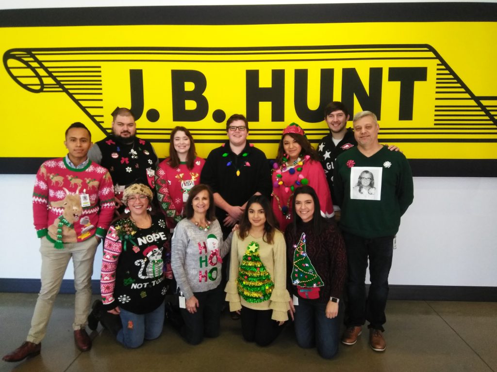 CDP team of eleven people dressed up for Christmas in front of J.B. Hunt sign.