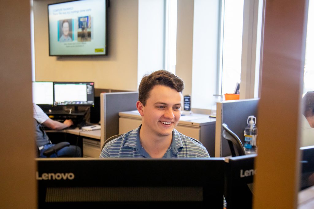 J.B. Hunt employee smiles working at his computer.