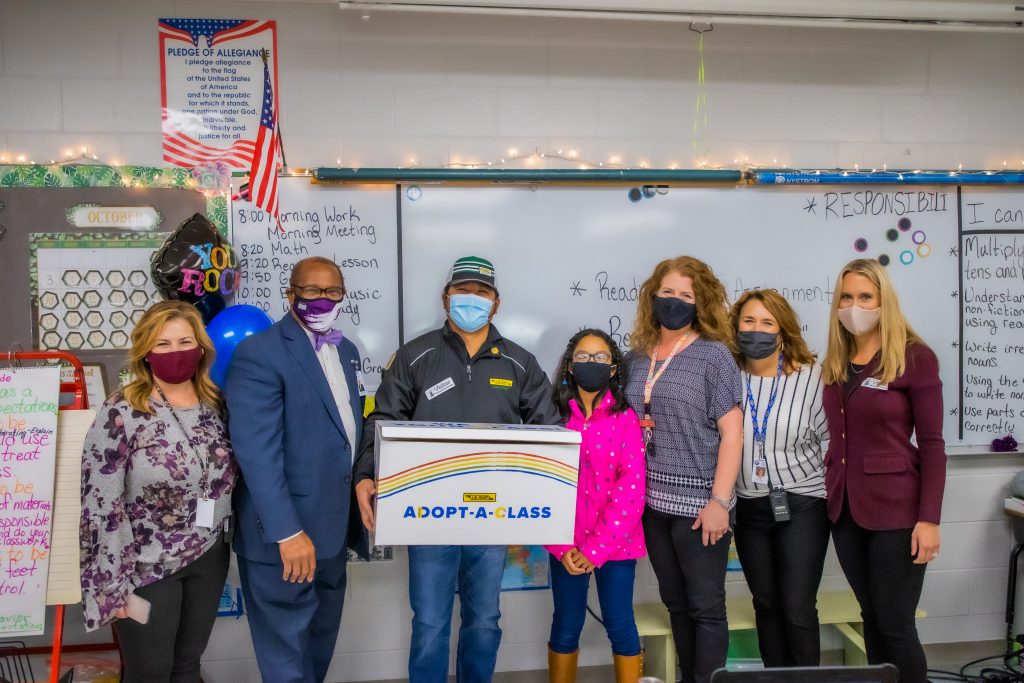 J.B. Hunt driver poses with teacher and school administration during the 2021 Adopt-a-class event.