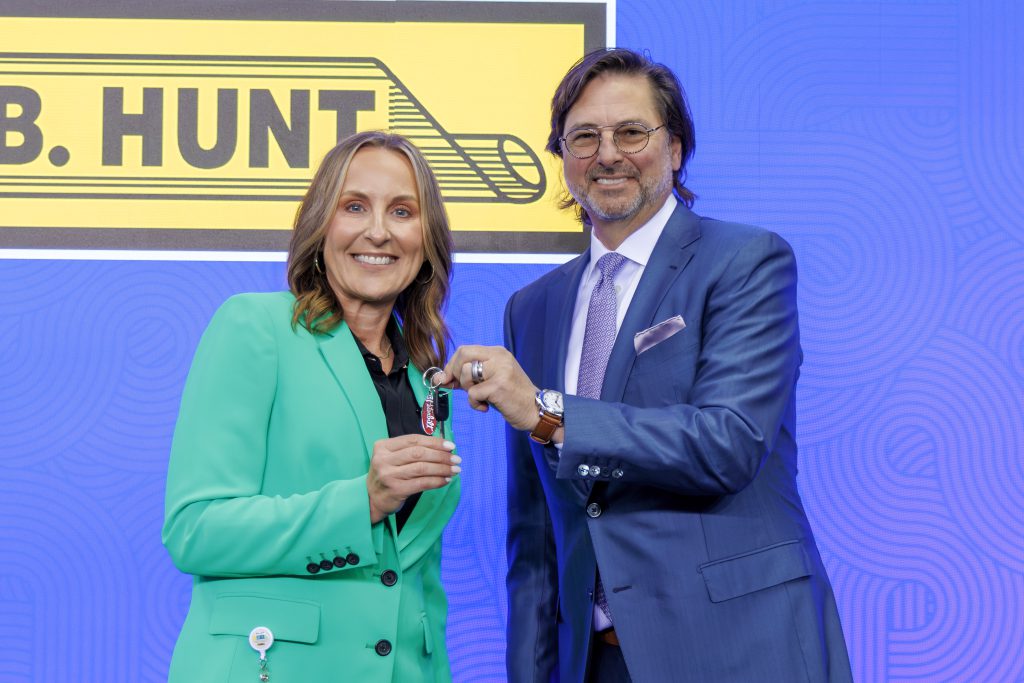 J.B. Hunt incoming CEO and President of the company, Shelley Simpson, being handed keys by outgoing CEO and Chairman of the Board, John Roberts.