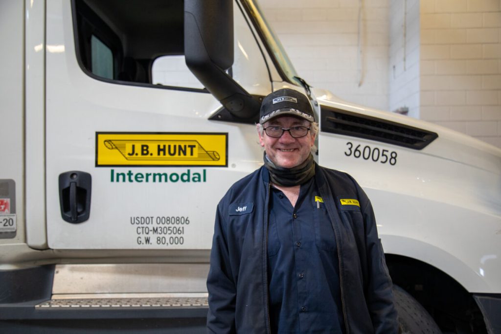 J.B. Hunt maintenance technician smiling next to one of our company intermodal trucks.