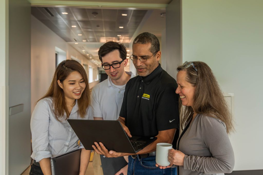 J.B. Hunt employees working together on a laptop at our corporate campus in Lowell, AR.