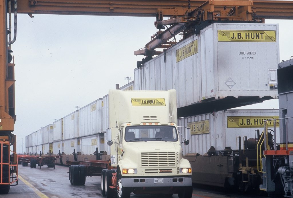 J.B. Hunt truck surrounded by Intermodal containers.