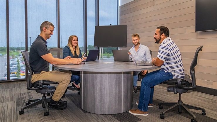 Employees meeting around big screen in a meeting room at the J.B. Hunt corporate headquarters