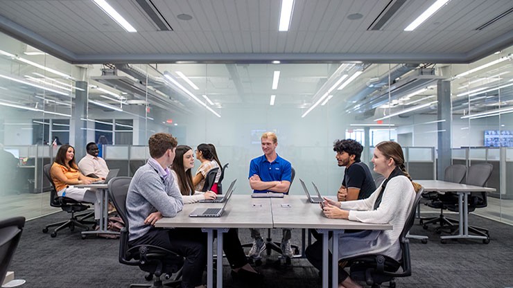  J.B. Hunt interns meet around a table in one of the meeting rooms in the corporate office