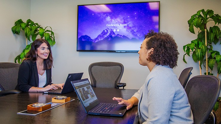 Two employees smiling in a J.B. Hunt meeting room