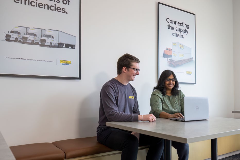 two employees meeting around a laptop in a common area