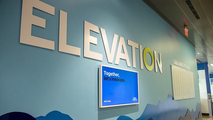 Blue wall with the word elevation written in large letters above a framed blue square that says "together let's innovate."