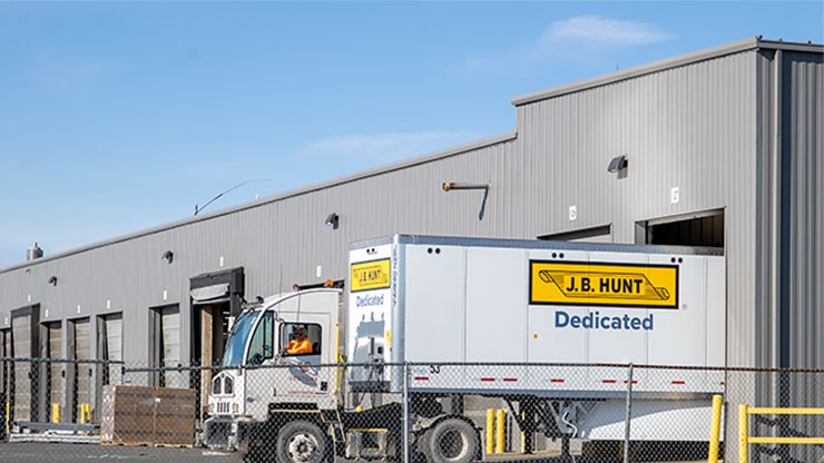 A J.B. Hunt DCS truck parks at a distribution center