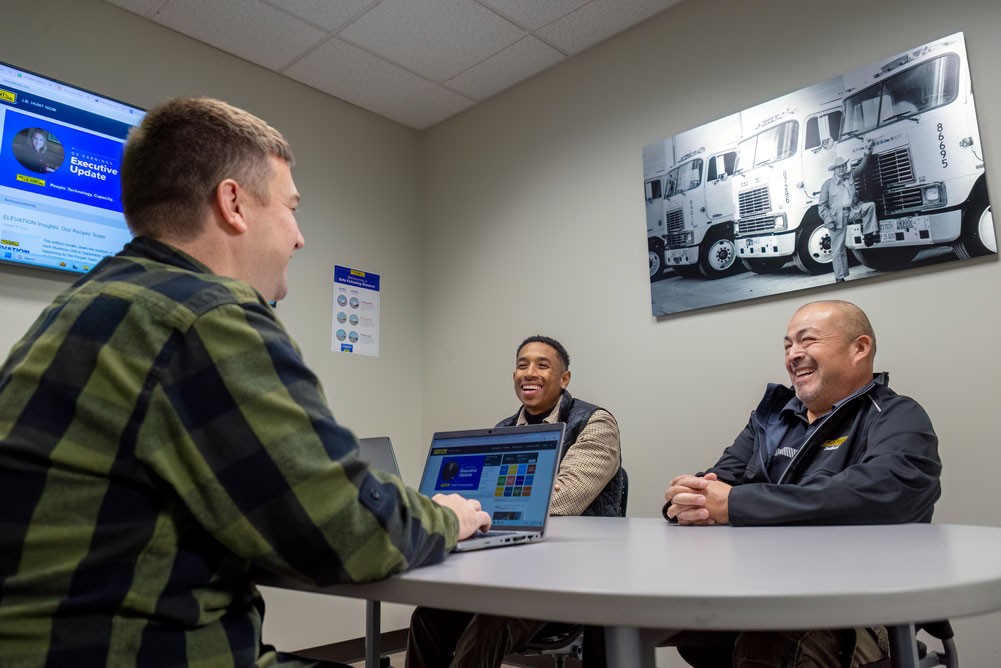 three field employees having a meeting in an office