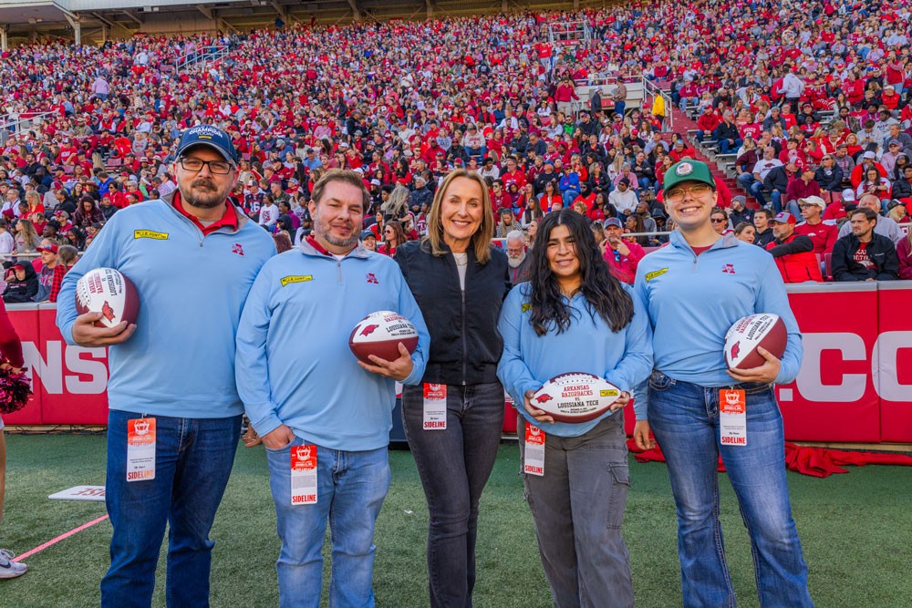 veterans pose at arkansas razorbacks game with ceo shelley simpson