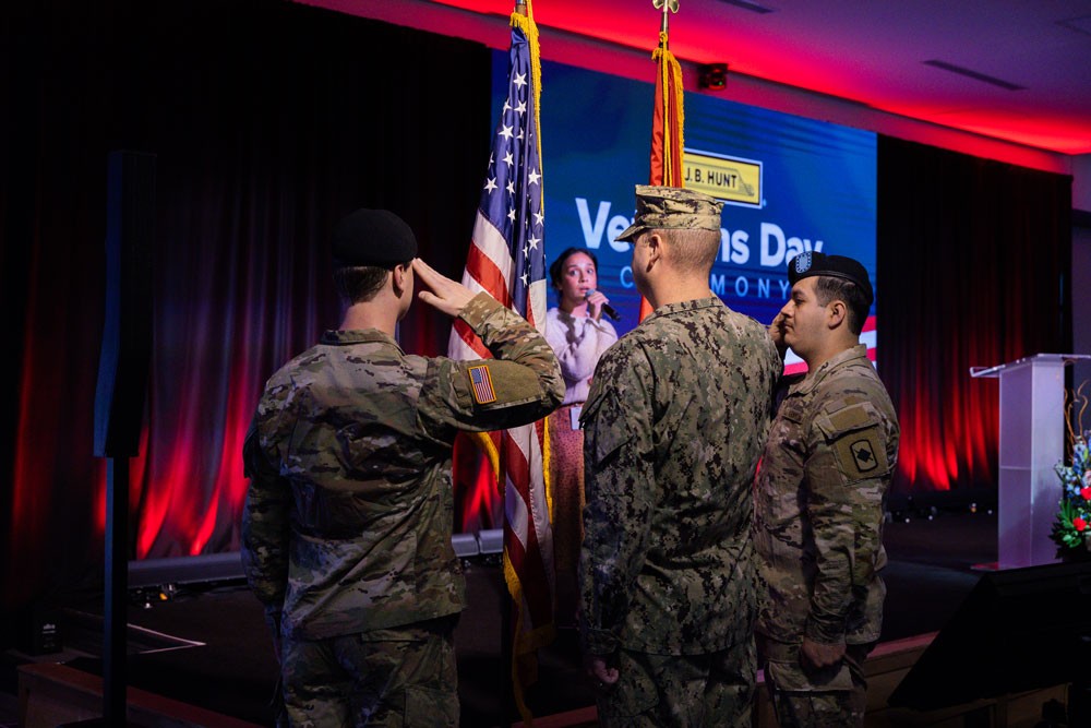 servicemembers salute flag during ceremony